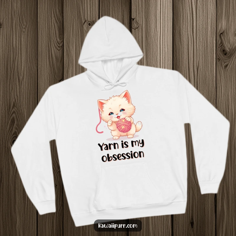 Funny Hoodie: Soft sweatshirt featuring a fluffy kitten character playfully swatting at a dangling sparkly yarn ball.